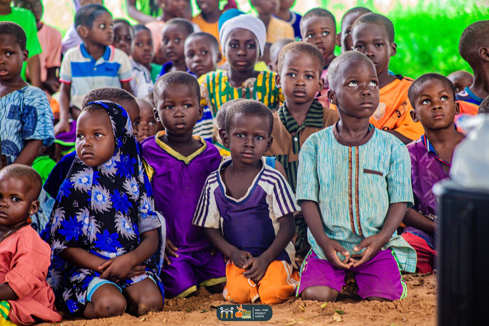 Children of Da-azio seated on the ground during the outreach