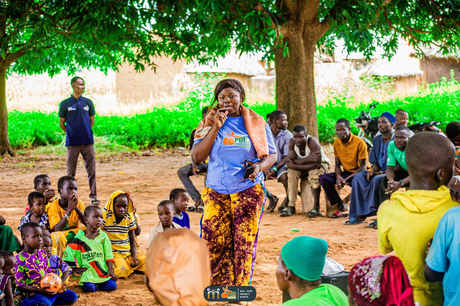 A team member ministers to the community under a large tree